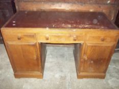 AN OAK LEATHER INLAID TWIN PEDESTAL DESK WITH INNER DRAWS
