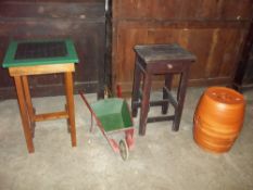 TWO TABLES, A DECORATIVE GARDEN WHEELBARROW AND A POTTERY BARREL PLANT STAND