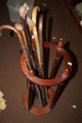 A STICK STAND AND A COLLECTION OF WALKING STICKS