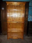 A TALL SOLID PINE BOOK SHELF/CASE