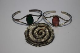 TWO WHITE METAL BANGLES TOGETHER WITH A WHITE METAL BROOCH