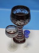 A LARGE BOHEMIAN RUBY OVERLAY GLASS GOBLET WITH GRAPE AND VINE DECORATION TOGETHER WITH TWO OTHER