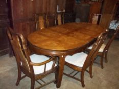 A LARGE OVAL EXTENDING DINING TABLE AND SIX CHAIRS INCLUDING TWO CARVERS