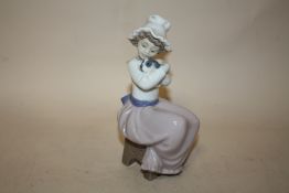 A NAO FIGURE OF A YOUNG GIRL HOLDING A PUPPY