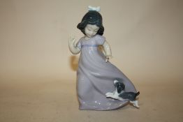 A NAO FIGURE OF A YOUNG GIRL PLAYING WITH A PUPPY