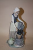 A NAO FIGURE OF A LADY COLLECTING WATER FROM THE FOUNTAIN