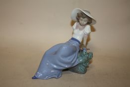 A NAO FIGURE OF A SEATED LADY WITH A BIRD