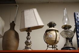 A FLORAL CERAMIC OIL LAMP WITH DUPLEX BURNERS TOGETHER WITH A GLASS EXAMPLE