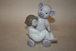 A NAO FIGURE OF A YOUNG GIRL ASLEEP WITH A TEDDY BEAR