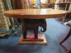 AN UNUSUAL MAHOGANY OVAL OCCASIONAL TABLE WITH A CARVED ELEPHANT SUPPORT H-58 CM W-94 CM