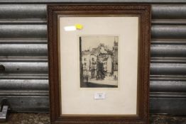A FRAMED AND GLAZED SIGNED ETCHING DEPICTING A TOWN SCENE