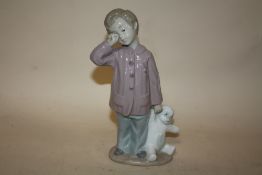 A NAO FIGURE OF A BOY READY FOR BED WITH HIS BEAR