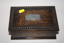 AN ANTIQUE CIGARETTE BOX WITH HALLMARKED SILVER PANEL TO LID, WITH COINS WITHIN