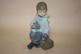 A NAO FIGURE OF A SEATED YOUNG BOY WITH A RABBIT