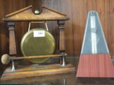 A MAHOGANY AND BRASS TABLE GONG TOGETHER WITH A METRONOME