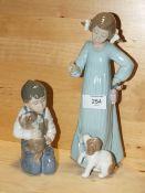 TWO NAO FIGURES OF CHILDREN WITH DOGS, NO MODEL NUMBER