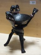 AN EBONISED WOODEN TRIBAL STYLE BOWL ON STAND
