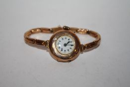 AN ANTIQUE 9 CT GOLD WRISTWATCH ON 9 CT GOLD TRAP, A/F