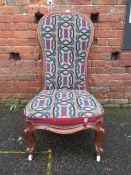 A VICTORIAN MAHOGANY FRAMED LOW NURSING CHAIR WITH TAPESTRY MATERIAL