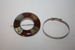 A SCOTTISH STYLE POLISH AGATE CIRCULAR BROOCH TOGETHER WITH A STERLING SILVER CHRISTENING BANGLE