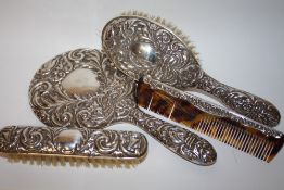 A HALLMARKED SILVER FOUR PIECE DRESSING TABLE SET WITH GREEN MAN DETAIL