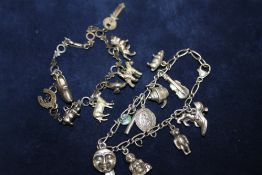 A SILVER CHARM BRACELET WITH ASSORTED CHARMS - APPROX 48.3G