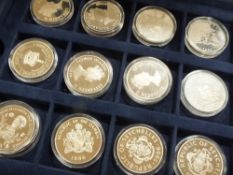 A CASED COLLECTION OF TWENTY FOUR COMMEMORATIVE SILVER COINS