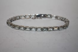 A LADIES SILVER GEM SET TENNIS BRACELET