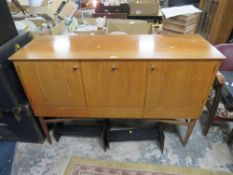 A RETRO TEAK SIDEBOARD WITH THREE CUPBOARDS ABOVE DRAWERS RAISED ON CYLINDRICAL LEGS H-94.5 W-140