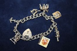 A SILVER CHARM BRACELET WITH ASSORTED CHARMS - APPROX 33.3G