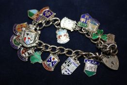 A SILVER CHARM BRACELET WITH ASSORTED CHARMS TO INCLUDE ENAMEL EXAMPLES - APPROX 42.2G
