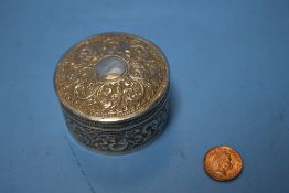 AN ANTIQUE INDIAN WHITE METAL BOX OF CIRCULAR FORM WITH PULL OFF LID