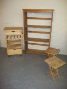 A KITCHEN WORK STATION TABLE, TWO FOLDING TABLES / STOOLS AND A PINK BOOKSHELF