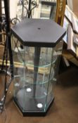 A HEXAGONAL GLASS DISPLAY CABINET