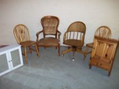 AN OAK SWIVEL OFFICE CHAIR, A REPRODUCTION BEDROOM CHAIR, TWO PINE DINING CHAIRS, A PINE WALL