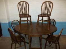 AN OAK EXTENDING DROPLEAF DINING TABLE SET WITH SIX CHAIRS