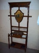 AN EDWARDIAN HALL COAT STAND WITH MARBLE SHELF AND BEVELL EDGED SHIELD MIRROR