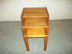 A VINTAGE TEAK NEST OF THREE TABLES