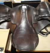 A VINTAGE ENGLISH LEATHER SADDLE WITH STIRRUPS