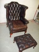A BROWN LEATHER QUEEN ANNE STYLED CHESTERFIELD CHAIR AND FOOT STOOL