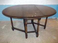 AN OAK DROP LEAF DINING TABLE