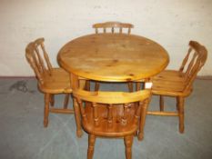 A ROUND PINE DINING SET WITH FOUR CHAIRS