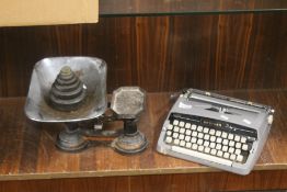 A SET OF CAST IRON WEIGHING SCALES WITH PAN AND WEIGHTS AND A BROTHER PORTABLE TYPEWRITER