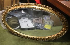 AN OVAL GILT FRAMED MIRROR, 104 X 58 CM