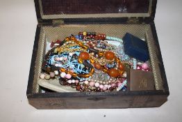 AN INLAID MAHOGANY LIDDED BOX CONTAINING COSTUME JEWELLERY TO INCLUDE AN AMBER STYLE NECKLACE