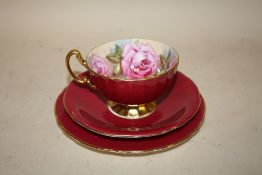 AN AYNSLEY CABBAGE ROSE PATTERN CUP, SAUCER AND SIDEPLATE TRIO