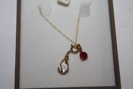 A 9 CARAT GOLD NECKLACE WITH TWO PENDANTS TO INCLUDE A RED GEM SET EXAMPLE