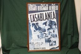 A LARGE REPRODUCTION FRAMED AND GLAZED ADVERTISING POSTER FOR WARNER BROS. 'CASABLANCA' OVERALL SIZE