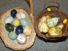 A BASKET OF POLISHED HARD STONE EGGS TOGETHER WITH TWO BASKETS OF HAND PAINTED WOODEN EGGS