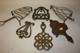 A COLLECTION OF BRASS AND OTHER IRON TRIVETS